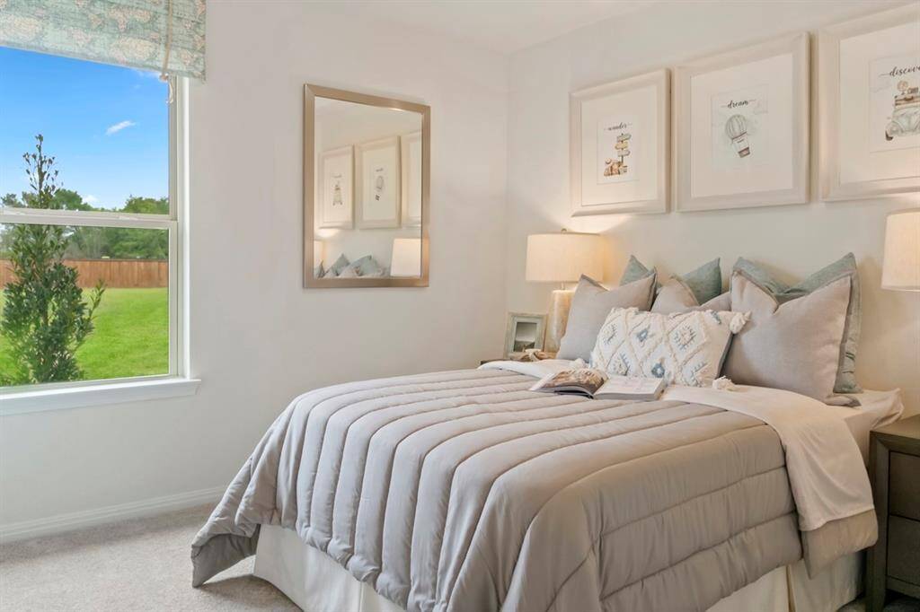 This secondary bedroom features high ceilings, custom paint, plush carpet, walk-in closet and large windows with window coverings!