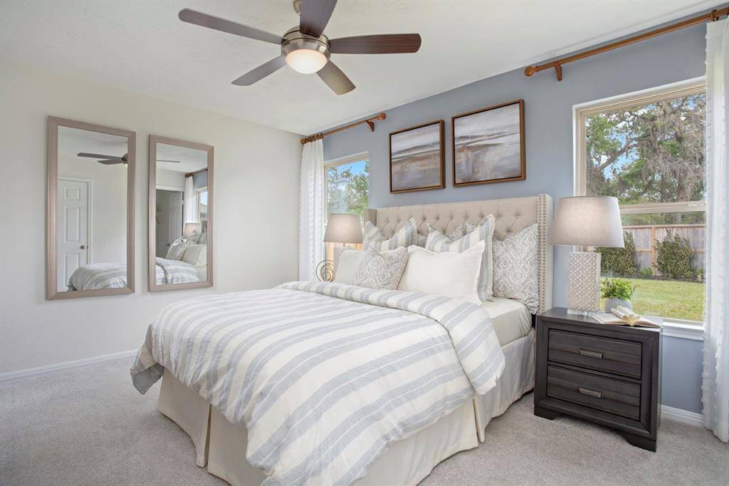 Come and unwind after a long day in this magnificent primary suite! This spacious room features plush carpet, warm paint, high ceilings, ceiling fan, and large windows with window coverings!