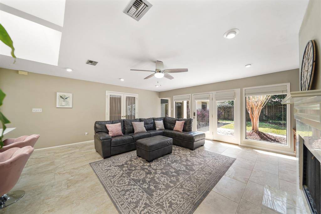 A French Door with Adjoining Stationary French Door, are flanked by Picture Windows in the Family Room for a view of the Landscaped Yard.  The French Door opens to the Flagstone Patio and to the Landscaped Yard.