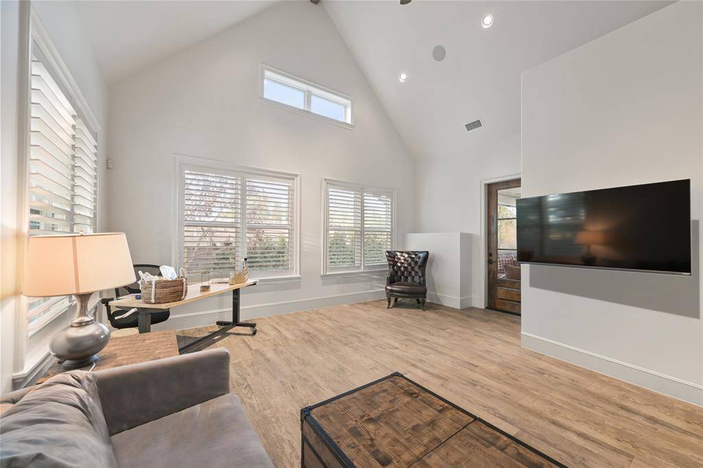 The first floor game room accesses the screened porch and is located near the kitchen and mud room space. the high ceilings allow natural light to flow through the space.