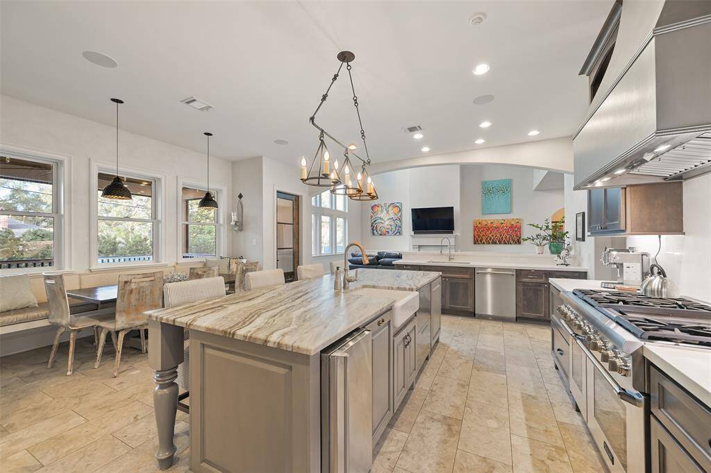 The island kitchen features professional appliances including a gas range with double ovens, nugget ice maker, microwave drawer, coffee maker and much more. The breakfast room overlooks the screened covered patio with wood burning fireplace and te kitchen is open to the great room.