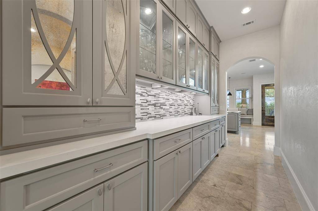 The butler's pantry offer lighted cabinets for display along with ample storage for all of your serving pieces. It accesses the formal dining room, the wet bar and the temperature controlled wine room.