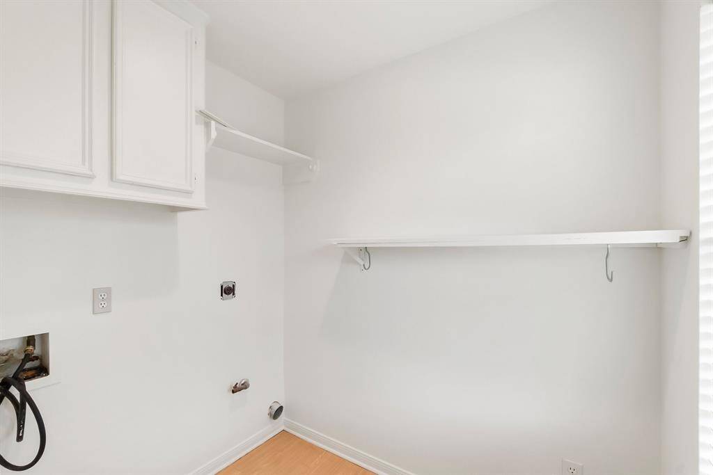 In house utility room with cabinets and shelves