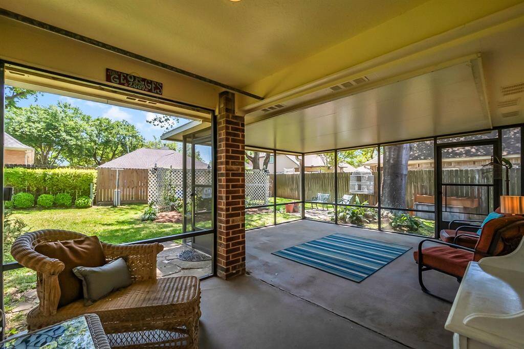 Screened in back porch overlooking lush landscaping