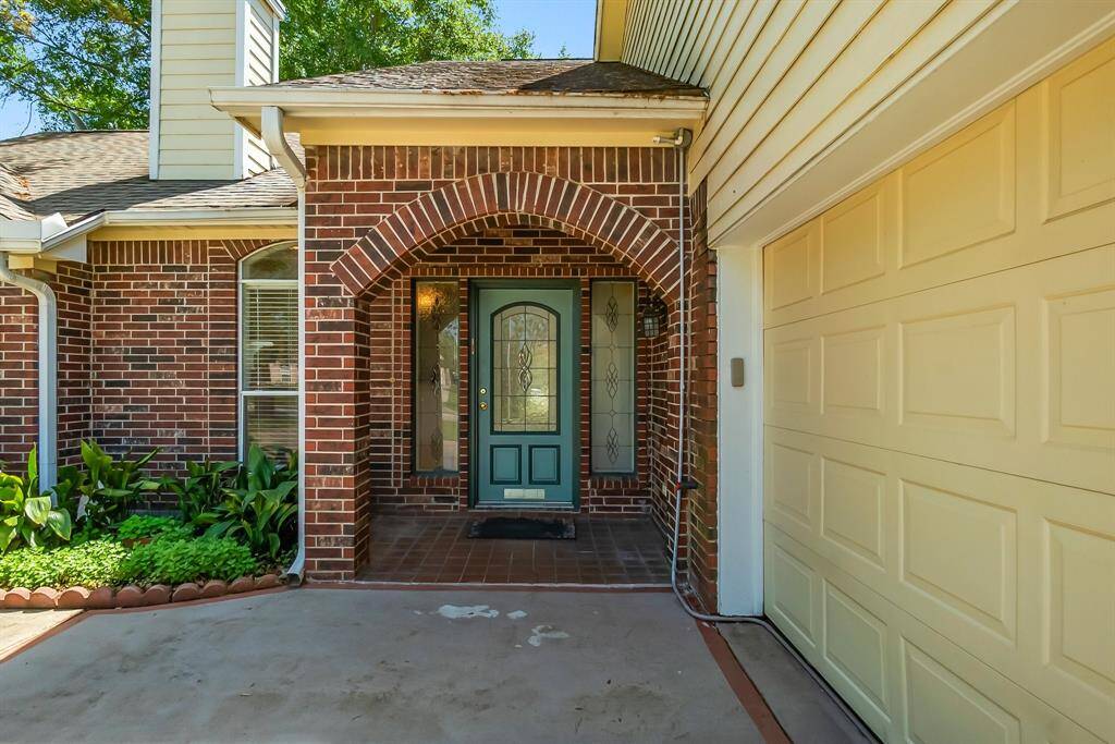 Covered front entrance to home with etched glass door and windows
