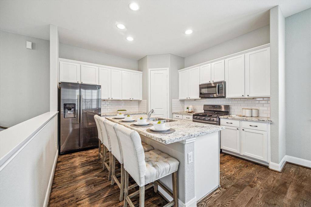Large island with overhang allows for additional seating for guests or casual dining.