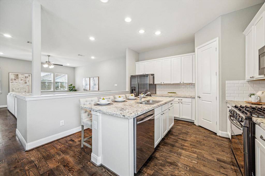 Beautiful kitchen with granite countertops features ample counter space and a walk in pantry. This view sows the living room view from the dining area.