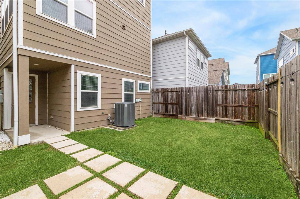Spacious fenced backyard with room for pets and play as well as an area for dining/seating.