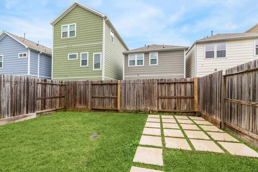 Alternate view of the backyard with pavers for seating area plus ample grass space for pets or play.