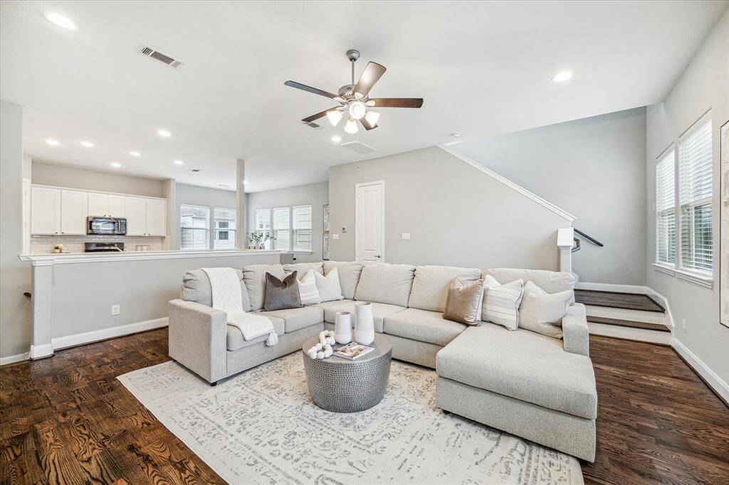 This views shows the second floor living space flowing into the kitchen and dining area. The open concept is ideal for hosting.