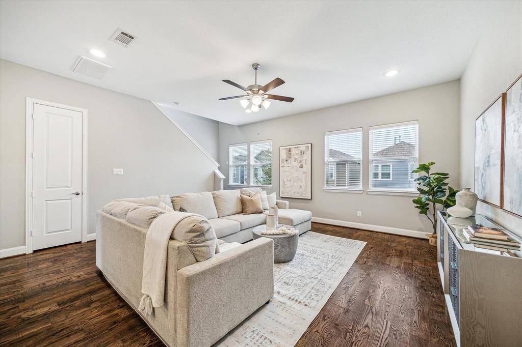 This alternate view of the living room shows the high ceiling and doors. The door is entry to the second floor powder room.