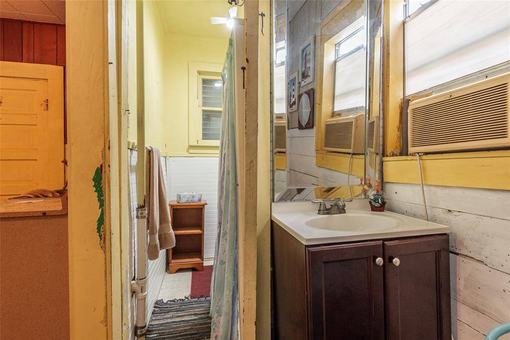 Vanity area sits next to bath area with walk-in shower.