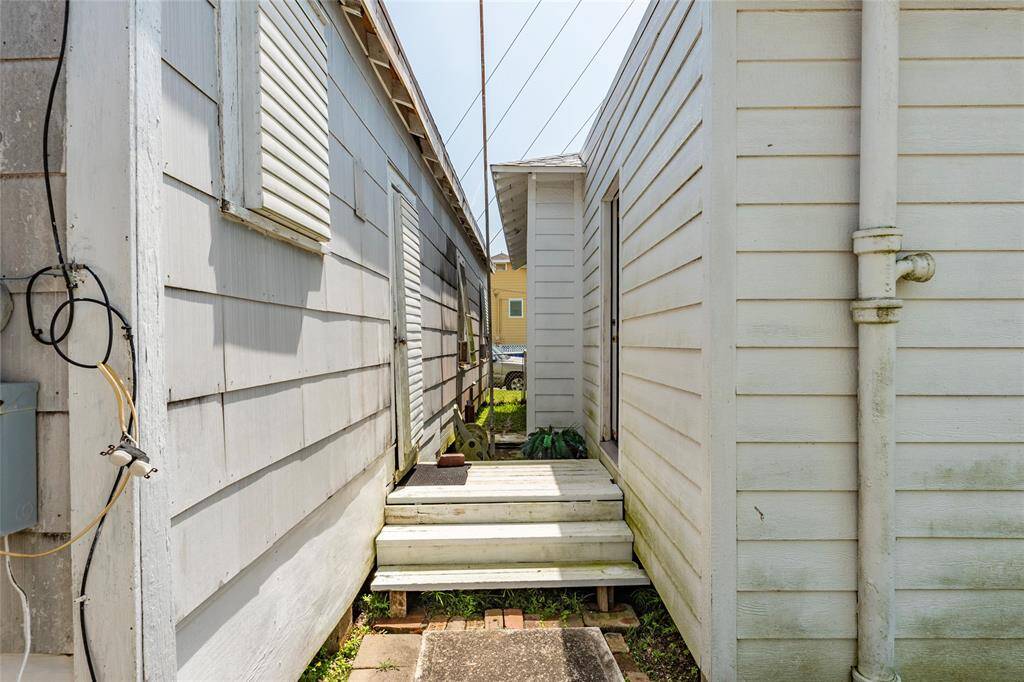 Side entry of home with the shutter lover door and window covers.  Easy access to building next door.