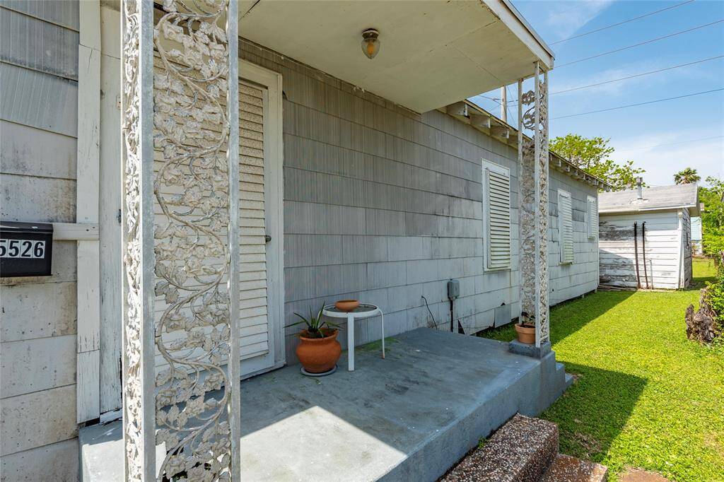 Front of home shows covered porch and front lawn.