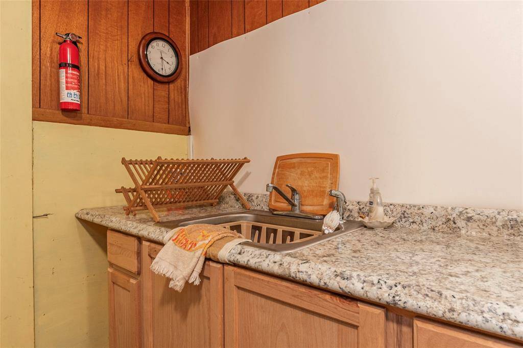 Full size sink w/ granite counter top and nice storage cabinets underneath.