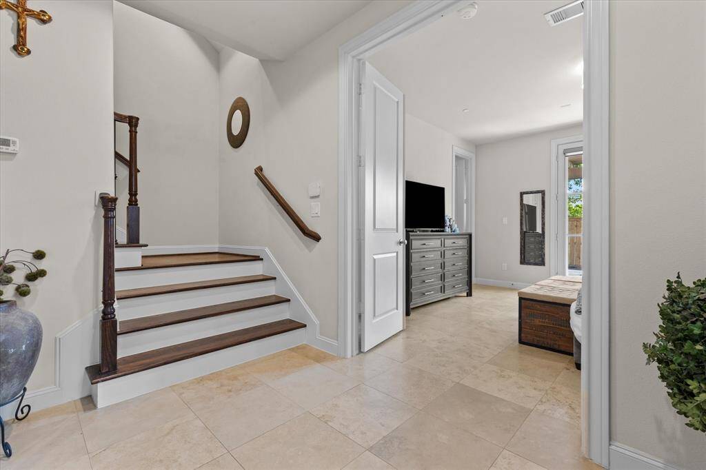 First level foyer with guest suite entry featuring travertine stone flooring.