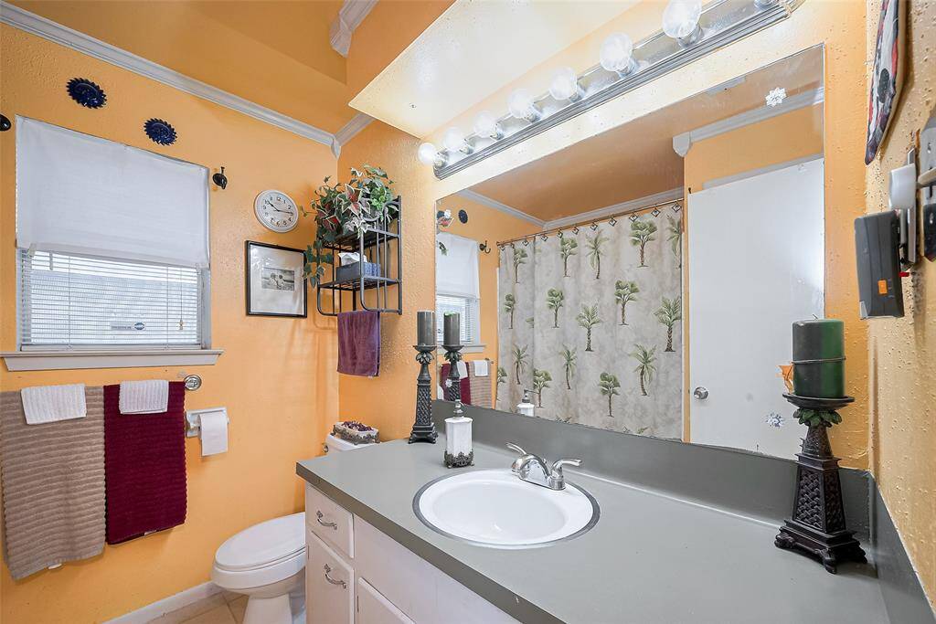 This cheerful full bath brings a pop of personality with sunny wall tones and decorative crown molding. Complete with a large vanity, plenty of counter space, and a full tub/shower combo, it’s both functional and fun—perfect for daily use or accommodating guests with ease.