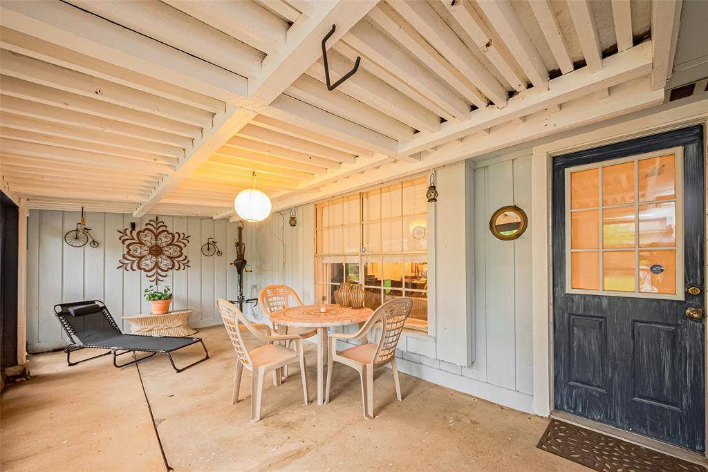 Step out back to this charming covered patio—perfect for relaxing or entertaining year-round. With unique wood ceiling details, warm ambient lighting, and space for both dining and lounging, it’s a cozy extension of the home that invites easy outdoor living. Whether you're sipping morning coffee or enjoying an evening breeze, this space delivers comfort and character.