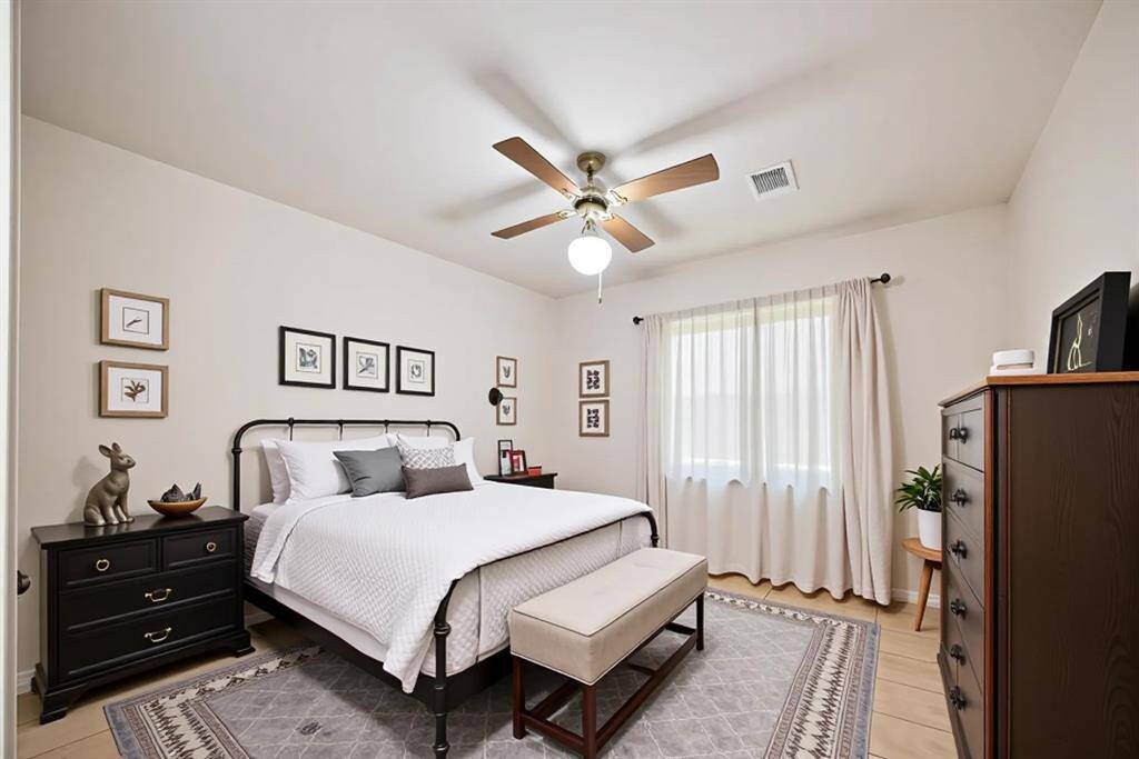 This virtually staged secondary bedroom offers a perfect balance of comfort and versatility. With soft natural light, neutral walls, and warm wood-style flooring, it’s ideal as a guest room, cozy retreat, or even a stylish home office. Thoughtfully arranged to show its full potential, the space feels both inviting and functional.
