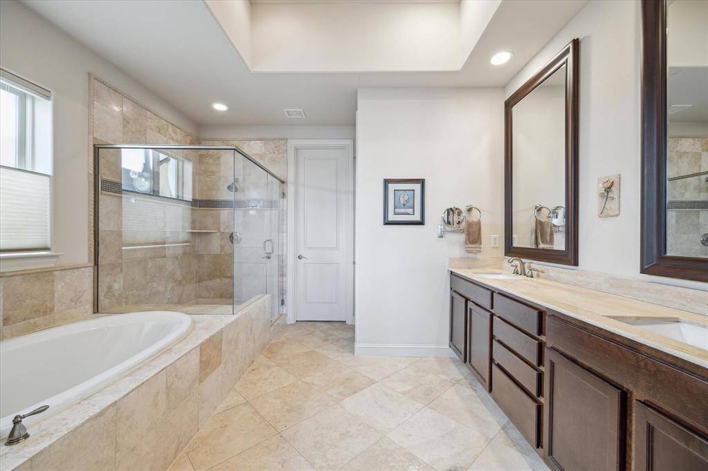 Primary bath featuring a large shower and tub and double sinks.