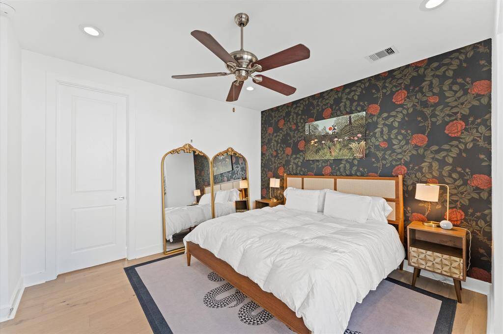 Spacious and serene primary suite with large windows, king-sized bed, walk-in closet, and stylish accents for comfort and rest.
