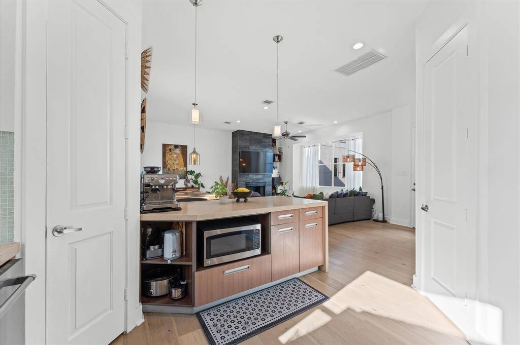 Fully equipped kitchen featuring stainless steel appliances, ample cabinet space, quartz counters, and a functional island perfect for meal prep or morning coffee.