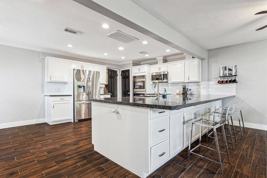 Crisp, updated kitchen with recent stainless appliances, updated cabinetry & granite counter tops.