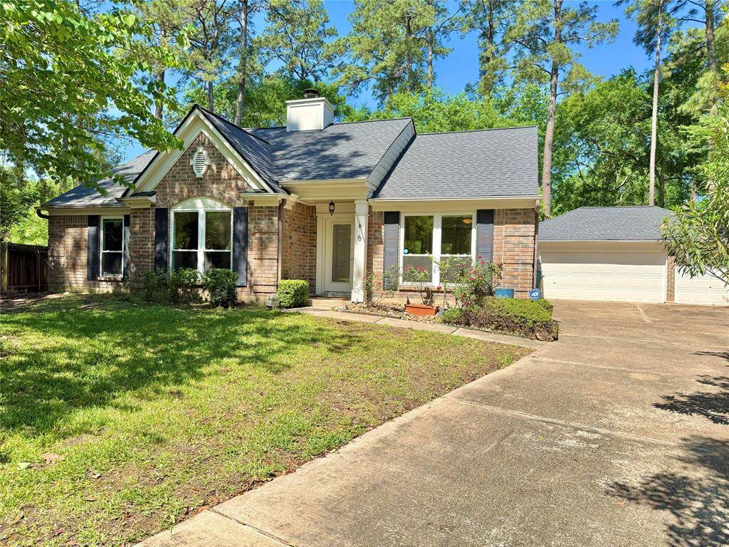 Charming brick home with a well-maintained front yard, mature trees, and a long driveway leading to a detached garage. Features large windows and a cozy entrance, perfect for enjoying a peaceful neighborhood setting.