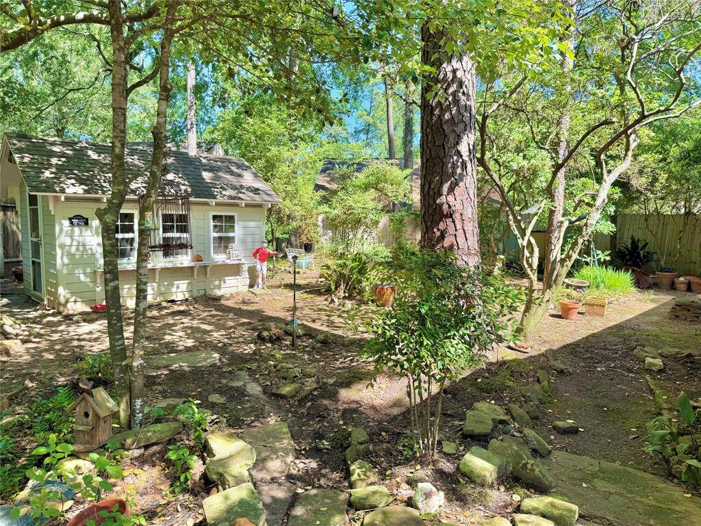 Charming backyard with lush greenery, mature trees, and a quaint garden shed. Ideal for relaxation and gardening enthusiasts.