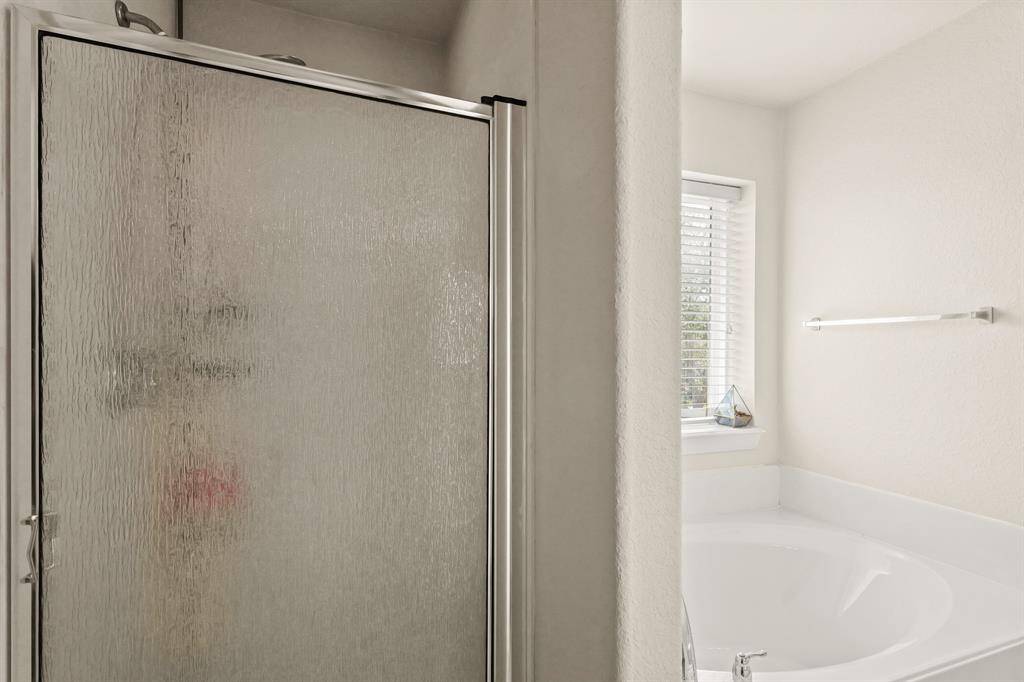 This ensuite features a gorgeous walk-in shower, and a large garden tub.