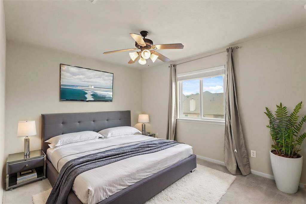 Virtually Staged: Beautiful secondary bedroom complete with carpet floors, a ceiling fan, a large window, and a built-in closet.