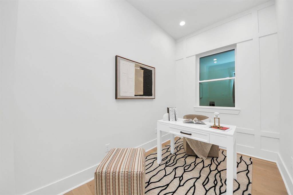 The downstairs study features a large window that brings in natural light, complemented by an accent wall, creating a stylish and inviting space on the first floor.