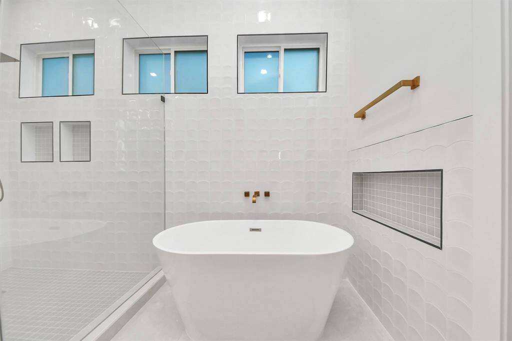 The Primary Suite is a bathroom dream, featuring a Woodbridge soaking tub with frosted windows for privacy. A custom-tiled nook adds convenience, perfect for anything you desire to enhance your experience.