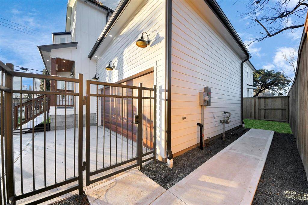 The spacious side yard highlights a builder upgrade with a strategically designed gutter downspout, assisting the walkway in remaining clear during rainfall.