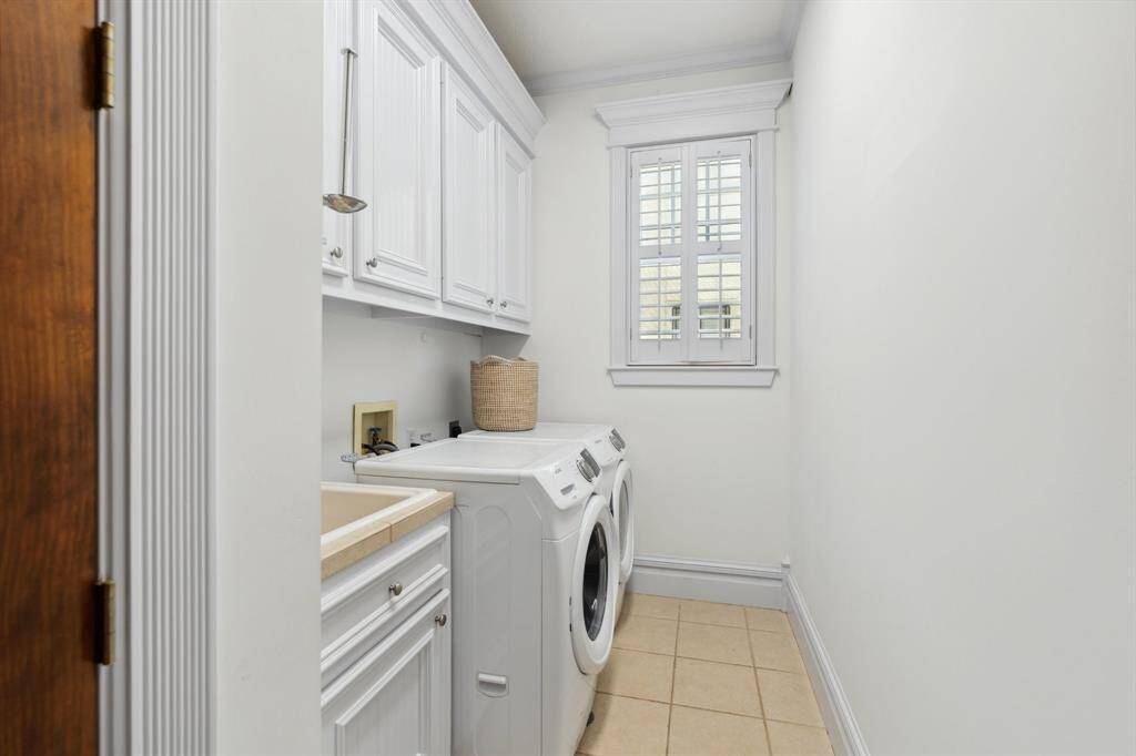 The second-floor laundry room is equipped with upper cabinets and a utility sink.