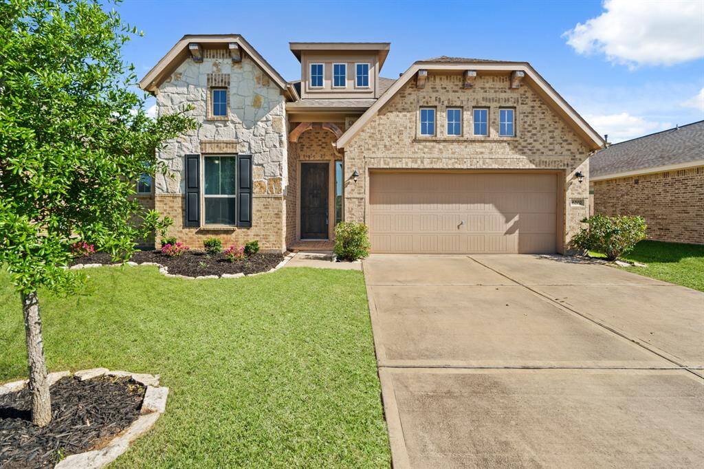 This charming home features a blend of stone and brick exterior with a well-maintained front lawn. It has a two-car garage and a welcoming entrance. Perfect for buyers seeking a mix of modern and rustic appeal.