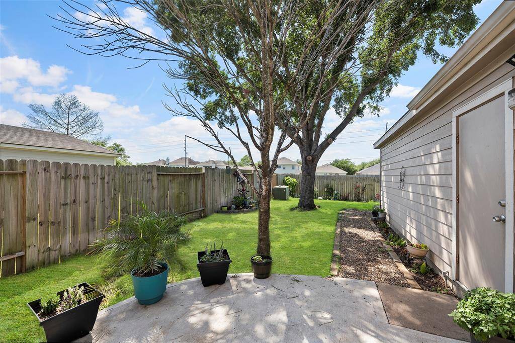 Beautiful back yard with mature trees and patio. The grass has been edited to see the potential of the area.