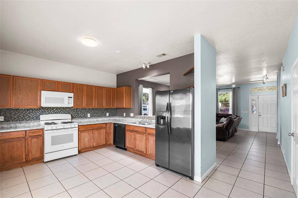 A lot of cabinets in this kitchen, and room enough to an island or a breakfast table. The refrigerator is included.