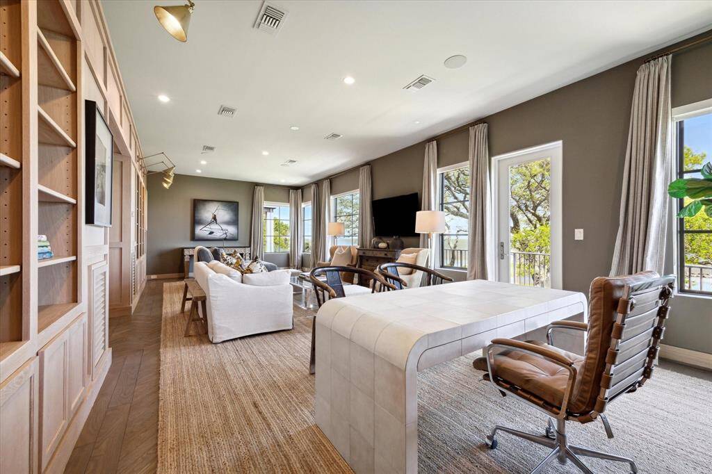 Elegant library with spectacular views and access to a large balcony overlooking the pool and bay.
