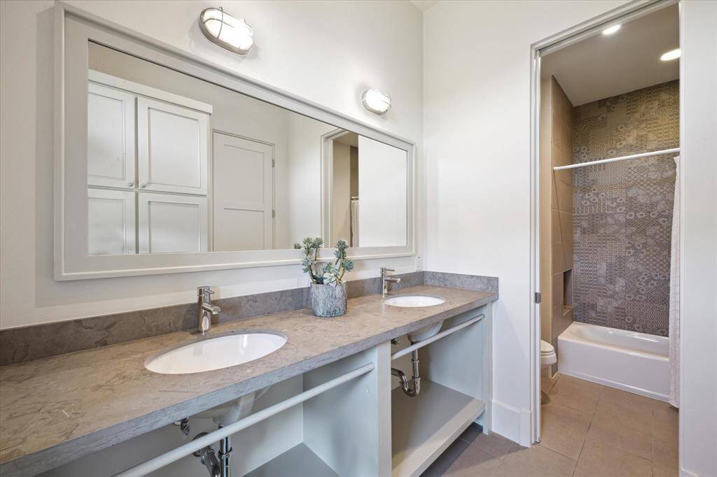 The bunk room en suite bathroom has double sinks and a shower/tub combo.