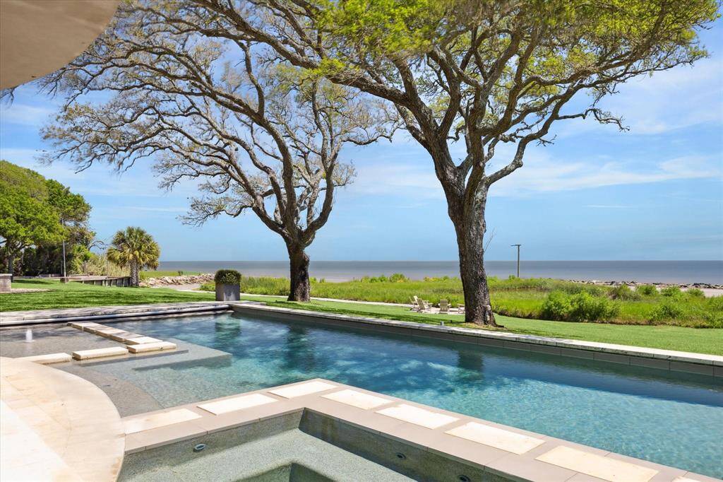 Take a dip in your secluded pool overlooking the bay. A few steps away is a grand covered patio with a summer kitchen and surround sound!