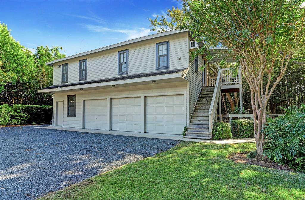 Detached guest quarters with a 3-car garage, workshop, and upstairs apartment. Perfect for guests, live-in help, or hobbyists/collectors.