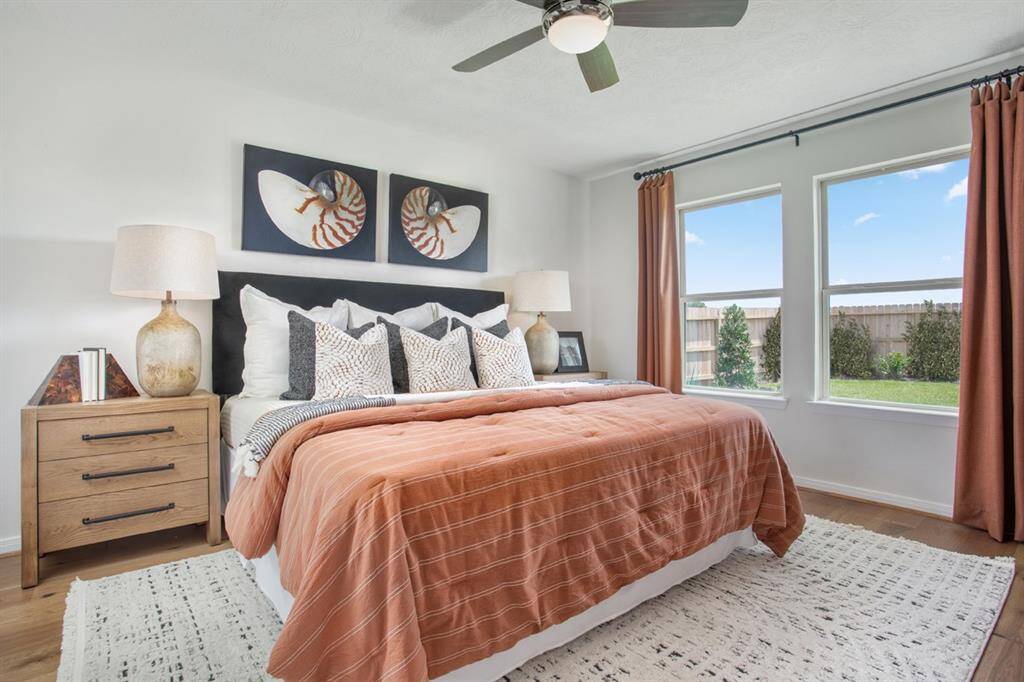 Come and unwind after a long day in this magnificent primary suite! This spacious room features engineered wood flooring, custom paint, high ceilings, ceiling fan, and large windows with window coverings. Note: window coverings and artwork to be sold with home.