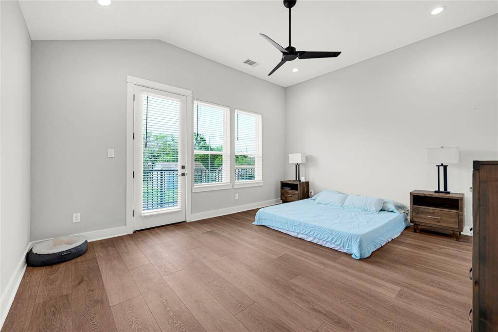 Primary bedroom w/ high ceilings and private balcony