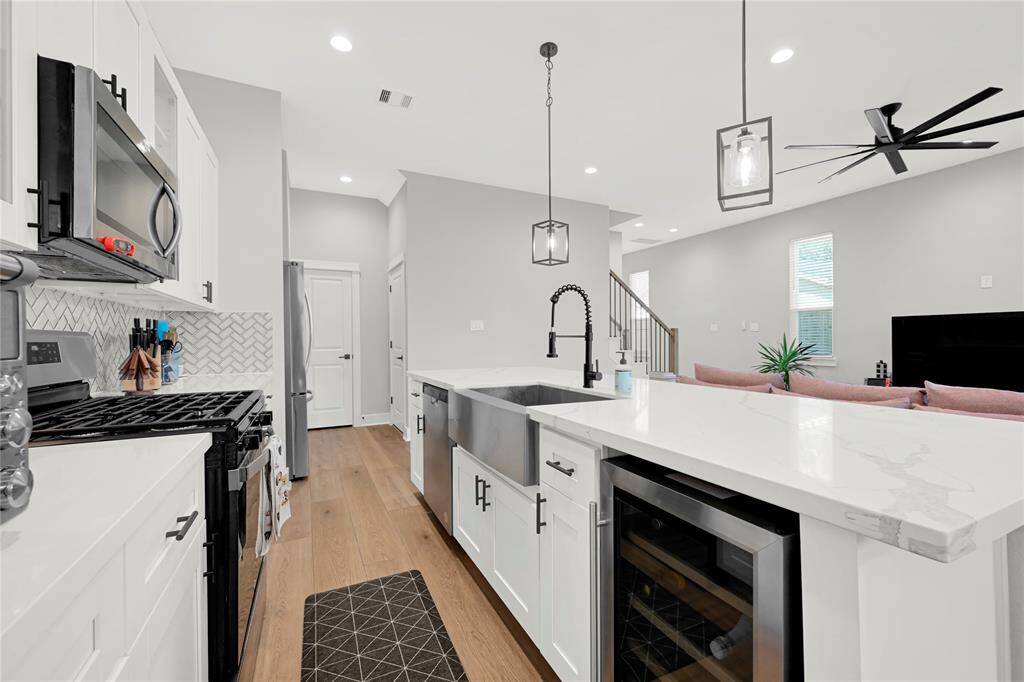 Kitchen w/ stainless steel appliances, gas range, farmhouse sink and wine fridge