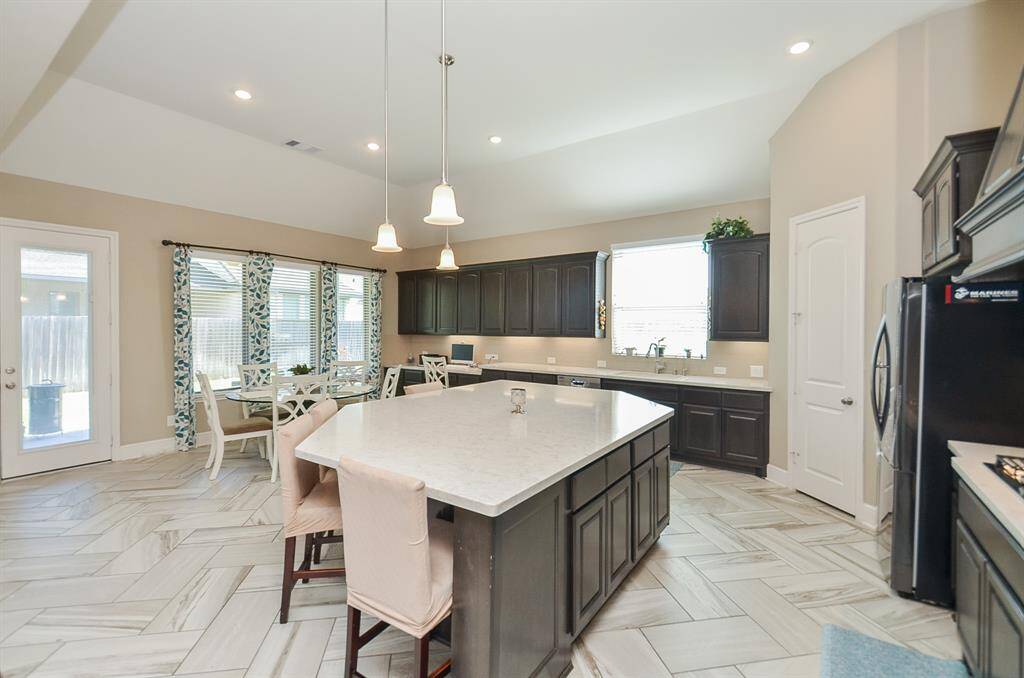 This kitchen is the answer to any chef's/host's dreams! The rich dark/light color contrast is sophisticated, yet warm. The huge space offers wide, easy-to-navigate floor paths, with cabinetry filling every inch of space, up and down. The quartz topped island is not just beautiful, but also practical for extra seating.