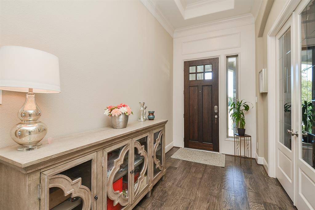 A high ceiling, pale earth toned walls and wood flooring fill this inside view of the front entrance. At right is a fabulous front room, perfect as a home office, if desired or used as a bedroom as it does have a closet as seen in the next pics!