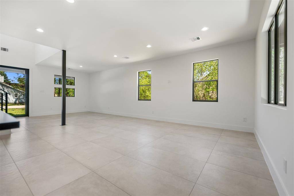 Natural light pours in from every angle, highlighting the sleek tile floors and airy design.