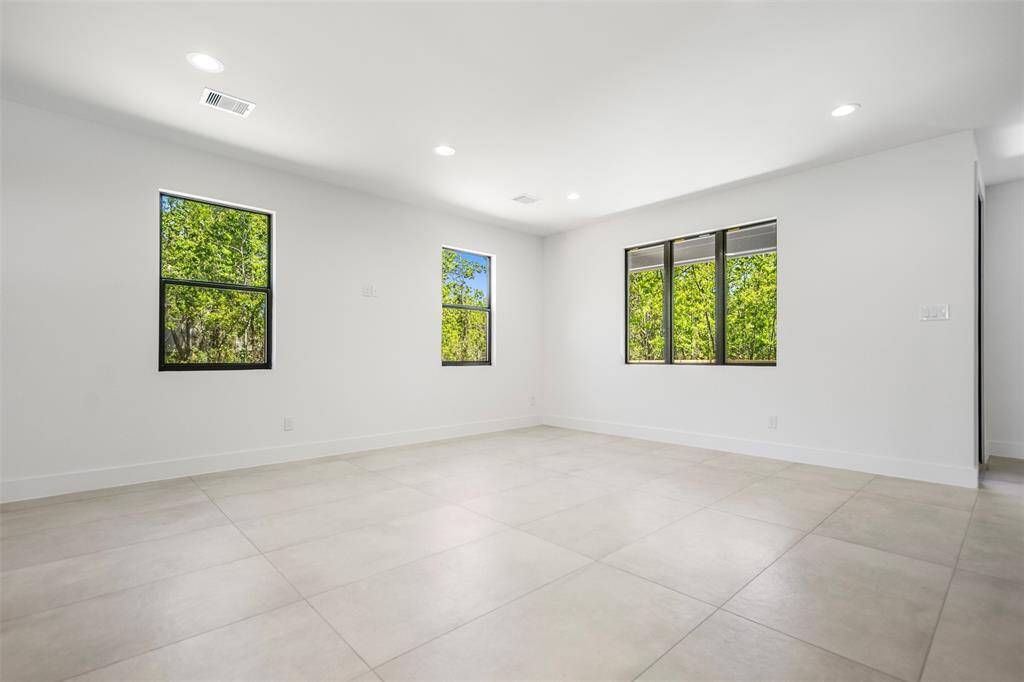 Surrounded by windows with tranquil green views, this spacious living area invites comfort and style.