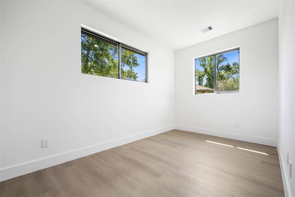 Flexible bedroom space with dual windows and serene views—ideal for a nursery, home office, or personal sanctuary.